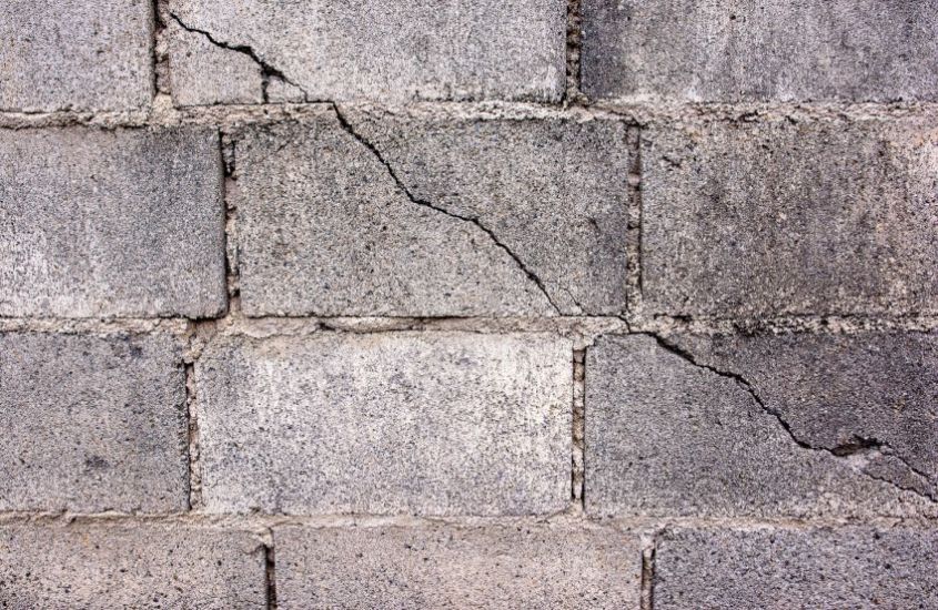 Cracked concrete block basement wall with visible foundation damage
